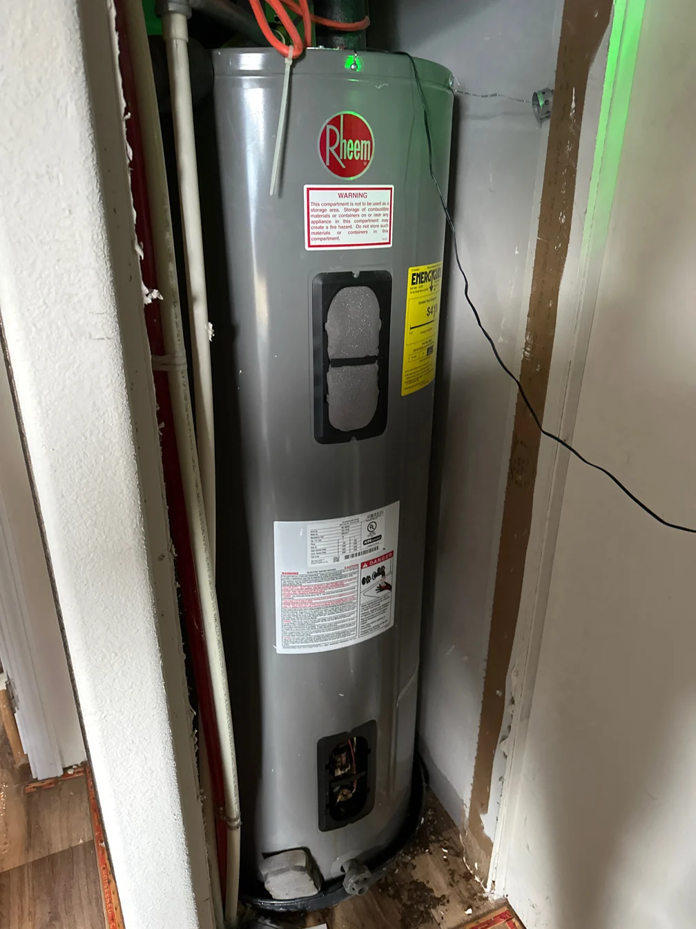 Rheem electric water heater installed in a utility closet